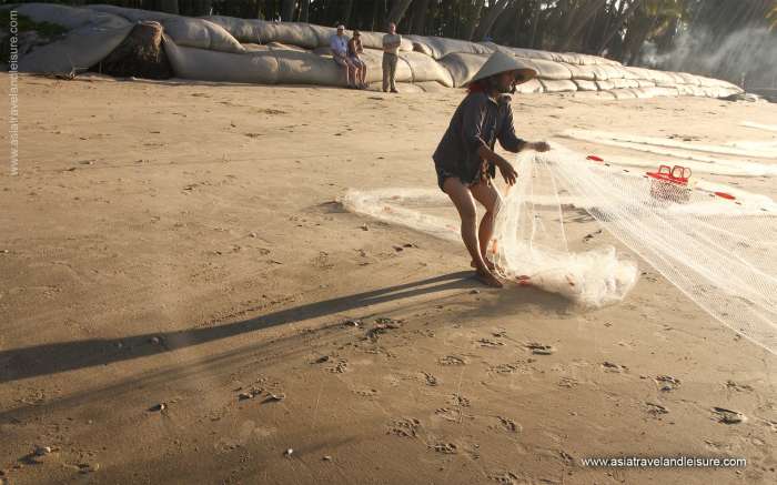 Fishermen pulling fishnet to the shore