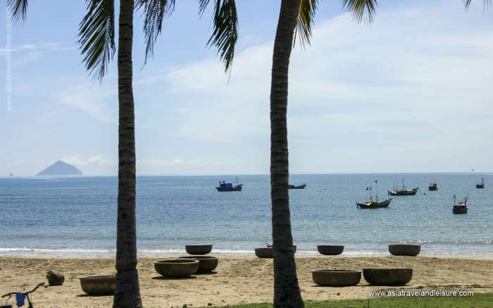 Fishing boats and bamboo baskets on beautiful beach in Nha Trang bay