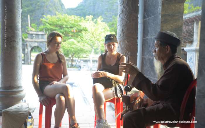 A senior man guardian of Thai Vi temple playing 
