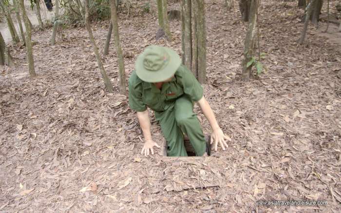 Soldier entering secret camouflaged tunnel at Cu Chi 