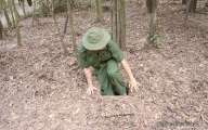 Soldier entering secret camouflaged tunnel at Cu Chi 