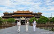 Girls walking gracefully wearing the Ao Dai at Ngo Mon gate