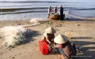 Fishermen pulling fishnet to the shore