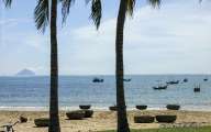 Fishing boats and bamboo baskets on beautiful beach in Nha Trang bay