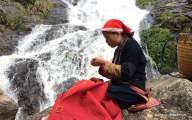 A local woman sewing on the bank of the stream