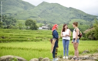 Local, travel consultant and foreign tourist on the rice field discovering the beauty nature 